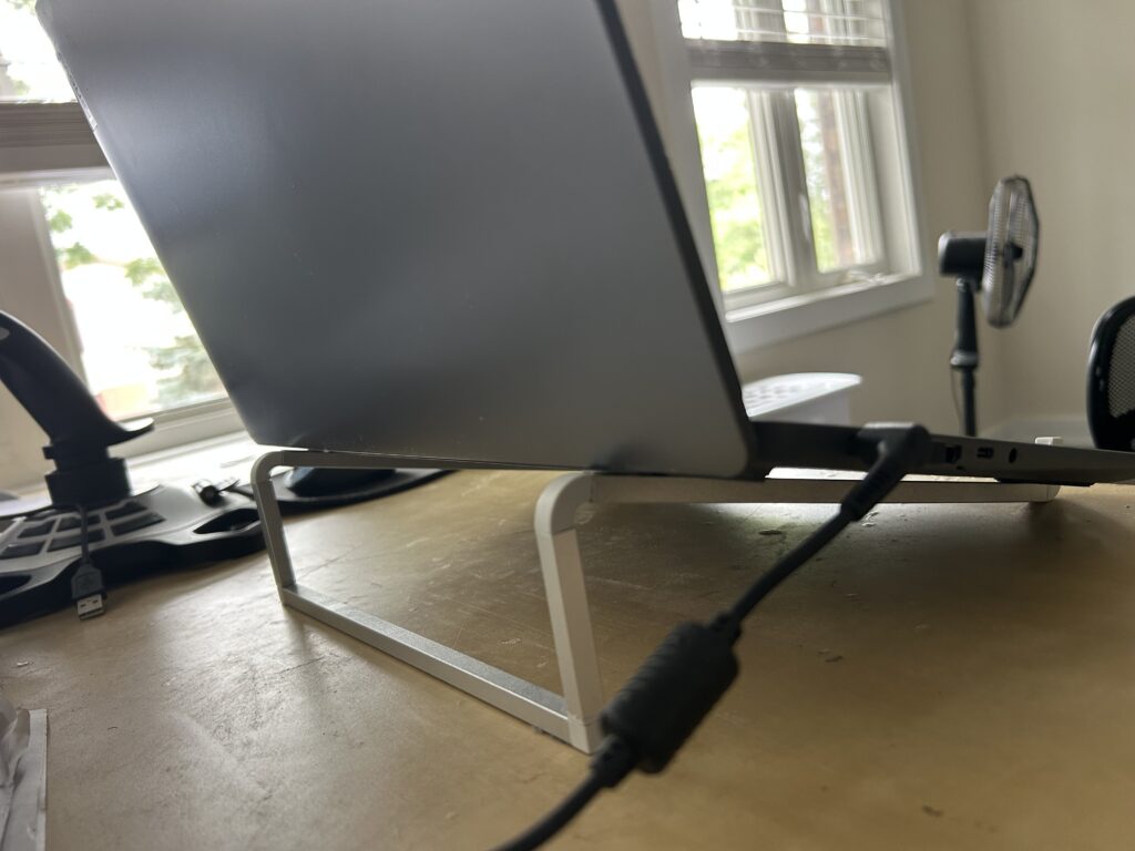 Laptop raised on a stand with open space underneath for airflow